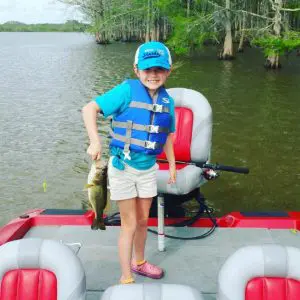Small girl river fishing holding a small bass Apalachicola Florida
