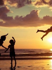 Father and children playing on the beach