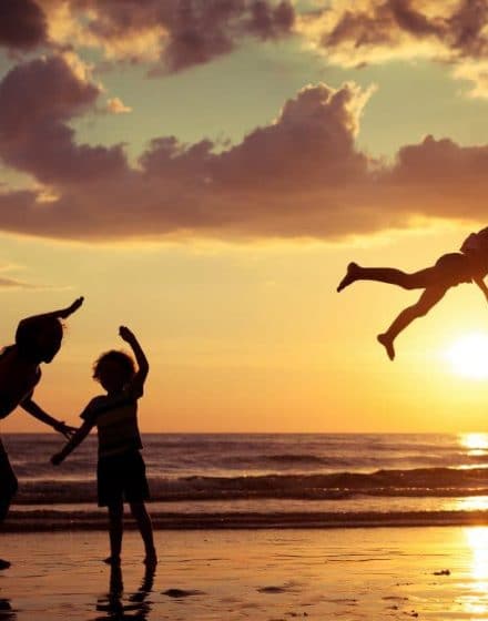 Father and children playing on the beach